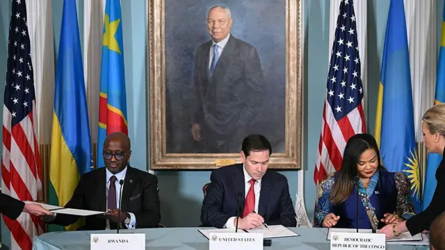 Minisitiri w'ububanyi n'amahanga w'u Rwanda Olivier Nduhungirehe na Minisitiri w'ububanyi n'amahanga wa DRC Thérèse Kayikwamba ubwo bashyiraga umukono ku masezerano y'amahoro muri minisiteri y'ububanyi n'amahanga y'Amerika, imbere ya Minisitiri Marco Rubio (hagati). Ifoto yafotorewe i Washington DC, ku itariki ya 27 Kamena (6) mu mwaka wa 2025.