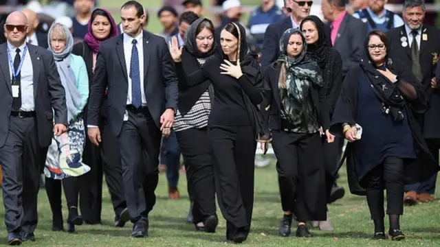 Jacinda Ardern, en foulard, de tout noir vêtue, salue la foule après la prière de vendredi à Christchurch.