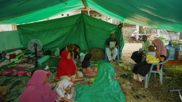 Warga beraktivitas di tenda pengungsian korban gempa di Desa Golo Sepang, Boleng, Manggarai Barat, Nusa Tenggara Timur, Kamis (20/8/2026). Warga terdampak memilih untuk mengungsi secara mandiri dengan mendirikan tenda darurat karena menderita trauma berat akibat gempa susulan yang sering terjadi. 