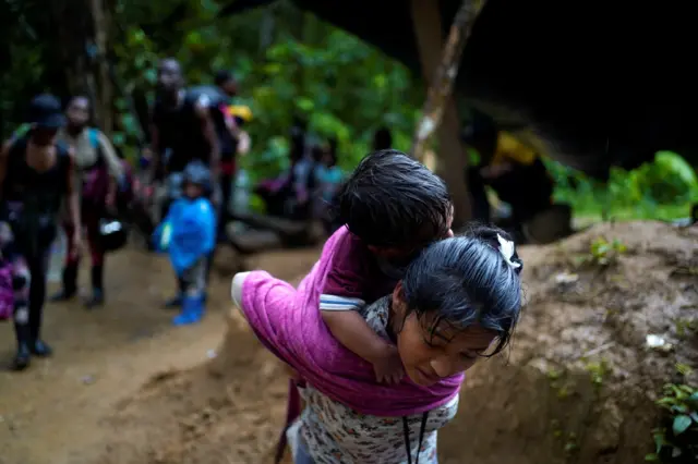 Una migrante acarrea un niño mientras cruza la selva del Darién, entre Panamá y Colombia, en su recorrido hacia Estados Unidos. Acandi, Colombia, 9 de julio de 2023. REUTERS/Adri Salido 