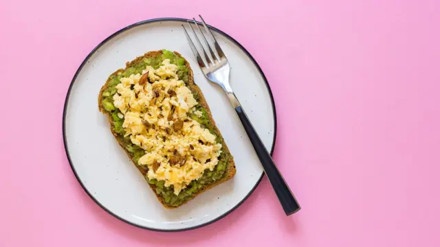 පාන් පෙත්තක් මත බිත්තර තබා ඇති සැන්විච් එකක ඡායාරූපයක්