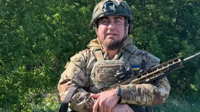 Манько позирует с оружием, в бронежилете и каске
