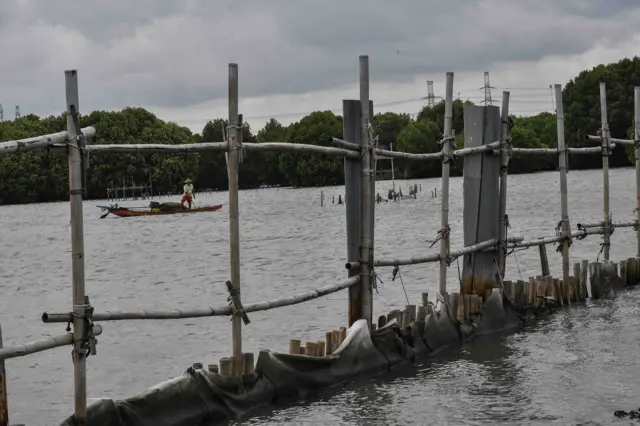 Kapal nelayan melintas di samping pagar laut di Pesisir Tarumajaya, Desa Segarajaya, Kabupaten Bekasi, Jawa Barat, Kamis (30/1/2025). Kementerian Lingkungan Hidup (KLH) menyegel area proyek pagar laut yang telah direklamasi karena diduga menyalahi Undang-Undang (UU) Nomor 32 Tahun 2009 tentang Perlindungan dan Pengelolaan Lingkungan Hidup. 