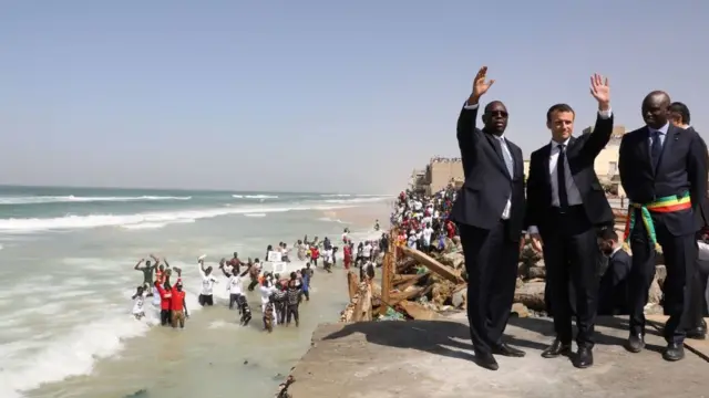 Les deux présidents Sall et Macron, avec le maire de Saint-Louis, au quartier des pêcheurs grignoté par l'érosion.