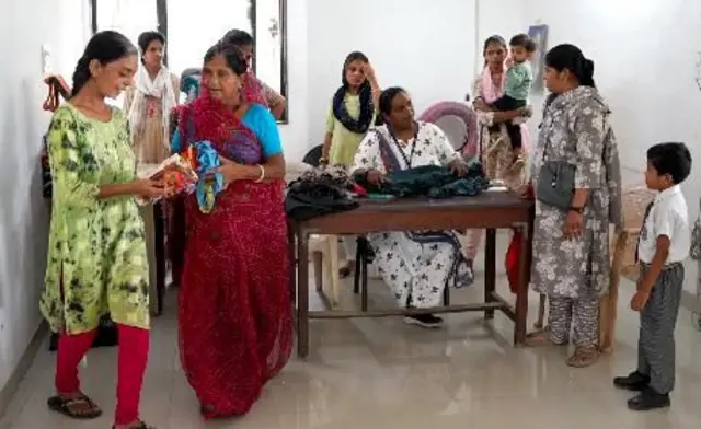 આરઆરઆર સેન્ટર પર માહિતી લેતા અને રજીસ્ટેશનમ કરવાતી મહિલાઓ
થેલી સીવડવવા આવેલી મહિલાઓ થેલી સીવતા પારુલ બહેન સાથે વાત કરી રહ્યા છે. માય થેલી યાદોની થેલી અમદાવાદ બીબીસી ગુજરાતી જૂના કપડાં પ્લાસ્ટિકનું પ્રદુષણ પ્રદૂષણ