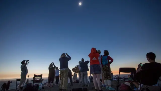 Pessoas assistem a um eclipse solar total