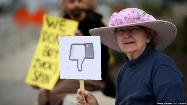 A protester with the group 'Raging Grannies' holds a sign during a demonstration outside of Facebook headquarters on April 5, 2018 in Menlo Park, California.