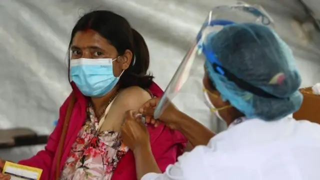 खोप लगाउँदै स्वास्थ्यकर्मी