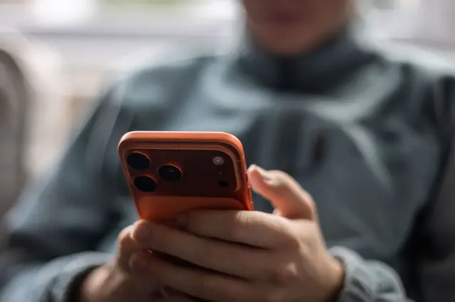 Дюдина з телефоном в руках