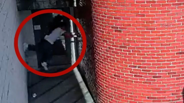 Screen grab of a video showing the escapee climbing up a wall