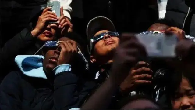 أشخاص يرصدون ظاهرة كسوف الشمس