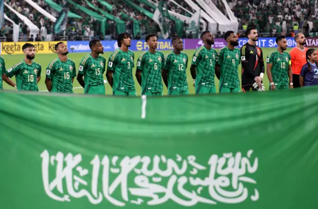 يقف لاعبو المنتخب السعودي خلال تأدية النشيد الوطني قبل اللقاء الحاسم أمام العراق في التصفيات الآسيوية المؤهلة إلى كأس العالم 2026