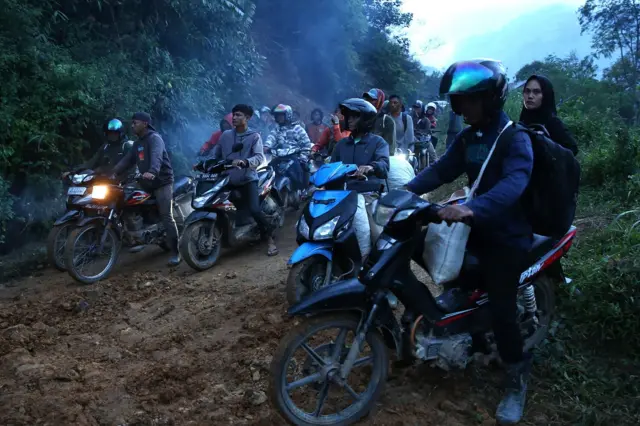 Warga antre melintasi badan jalan lintas Geumpang-Pameu-Takengon saat dibersihkan di Desa Panton Tengah, Rusip Antara, Aceh Tengah, Aceh, Rabu (24/12/2025).