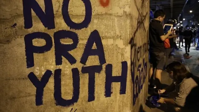 ผู้ชุมนุมกลุ่ม "ราษฎร" เขียนข้อความต่อต้าน พล.อ.ประยุทธ์ ระหว่างการชุมนุมที่แยกราชประสงค์และสำนักงานตำรวจแห่งชาติเมื่อวันที่ 18 พ.ย.