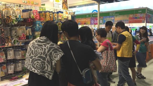 游客在书展选购特价文具。