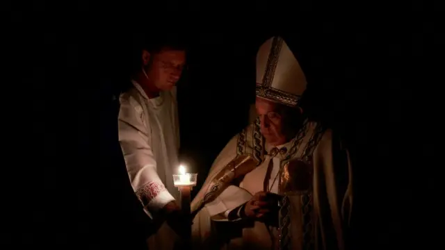 The Pope looks at a candle during the Easter Vigil