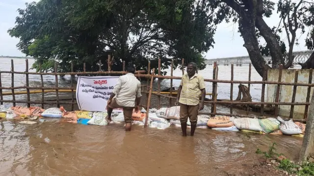 రాజమహేంద్రవరం నగరంలోకి వరద నీరు ప్రవేశించకుండా రోడ్ కం రైల్ వంతెన దిగువన ఇసుక బస్తాలు వేస్తున్న మున్సిపల్ సిబ్బంది