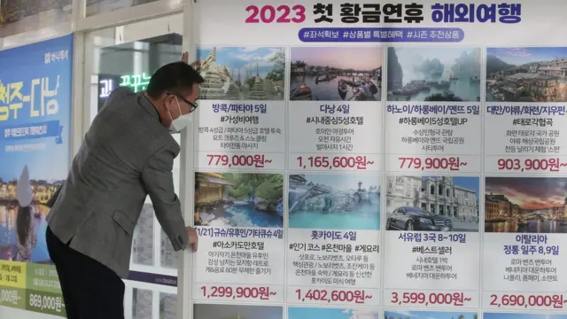 코로나19 방역 규제 완화로 해외여행 수요가 증가하고 있는 지난 5일 대전 서구의 한 여행사가 여행상품 현수막을 붙이고 있다