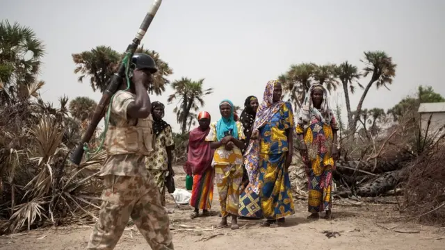 ologun kan n kọja niwaju awọn obinrin kan