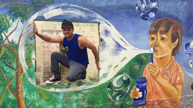 Kelvin en un mural pintado por su grupo.