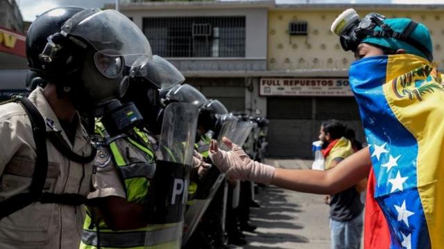 Policías se enfrentan a manifestantes en Venezuela.