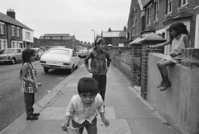 ታዳጊዎች በለንደን መንገድ ላይ ሲጫወቱ የሚያሳይ ጥቁር እና ነጭ ፎቶ