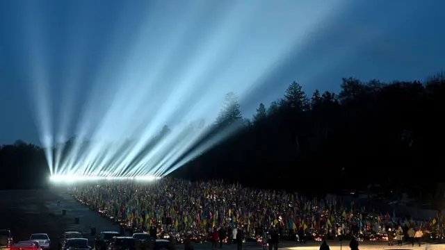 Лінія світла з прожекторів над могилами військових 