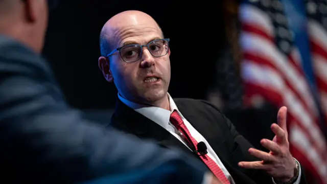 Stephen Miran, chairman of Donald Trump's Council of Economic Advisers speaks to anothermanwhile sitting near US flags during the Hill and Valley forum at the US Capitol in Washington on 30 April 2025