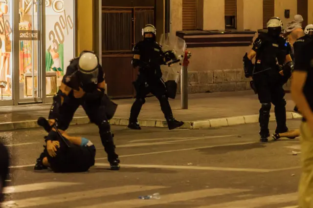 протест у ваљеву, полицајац туче момка који лежи на улици у Ваљеву