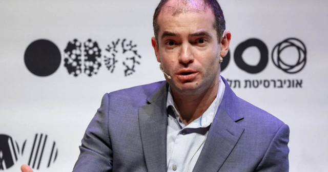 Ilya Sutskever em roupa social em evento e um microfone