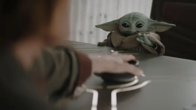 Грогу сидит за столом.