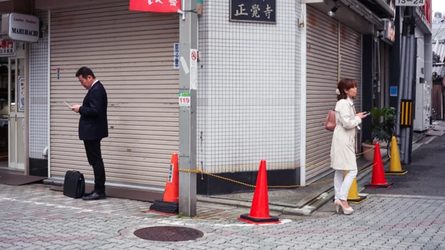 یک زن و مرد در خیابان پشت به پشت هم ایستاده‌اند