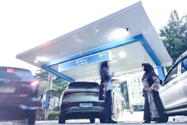 Pengendara menggunakan stasiun pengisian kendaraan listrik umum (SPKLU) di Medan, Sumatera Utara, untuk mengisi daya kendaraan listriknya (EV).