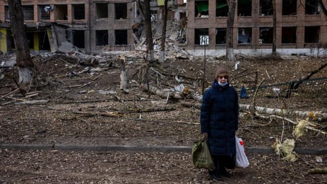 2月27日，在基輔附近的瓦西里科夫鎮，一名女子站在被俄羅斯導彈摧毀的建築前。