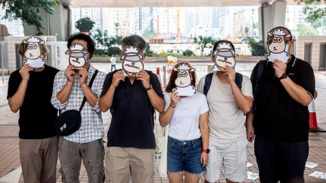 聲援「羊村繪本案」被告人的民眾在香港西九龍法院大樓外舉起羊群造型面具（23/7/2021）
