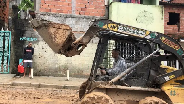 Trator carrega lama na ocupação