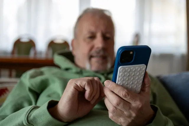 Starszy mężczyzna korzystający ze smartfona, zdjęcie stockowe
