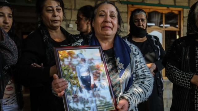 Mujeres sostienen el retrato de una niña matada por el ejército armano