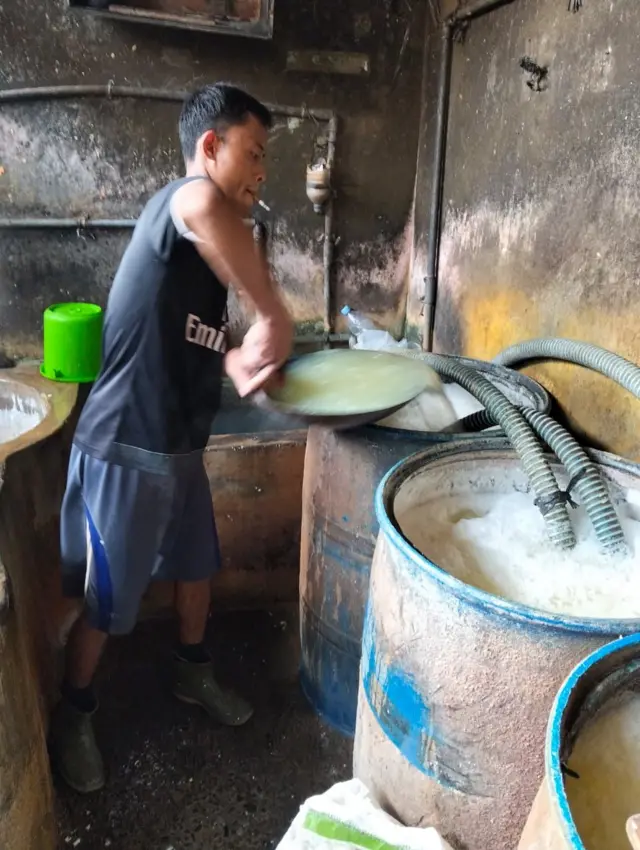 Seorang perajin dalam proses pembuatan tahu.