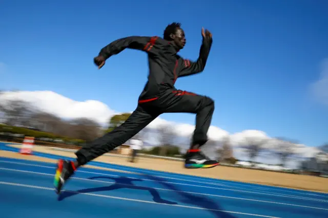 An athlete jumps on a racetrack.