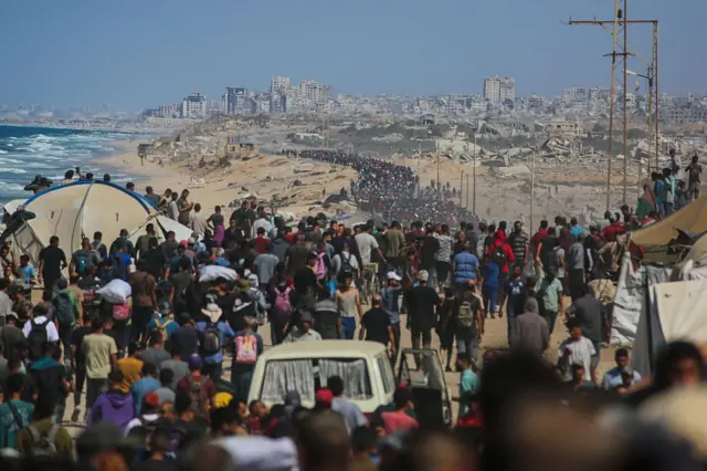 أعداد كبيرة من العائدين الفلسطينيين إلى مناطقهم في غزة، الصورة التقطت نهاراً قرب شاطئ البحر.