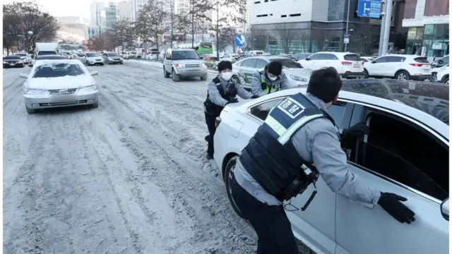 언덕 길에 미끄러지는 차들. 7일 오전 경기도 수원시 영통구 광교로에서 경찰들이 밤사이 내린 눈으로 언덕 길에서 미끄러지는 차량들을 밀고 있다