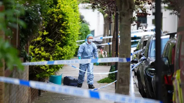 ケンティッシュ・タウンの火災現場付近を調べる捜査員