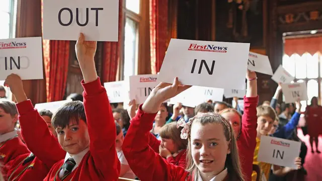 Дети держат листы бумаги с надписями "Уйти" и "Остаться"