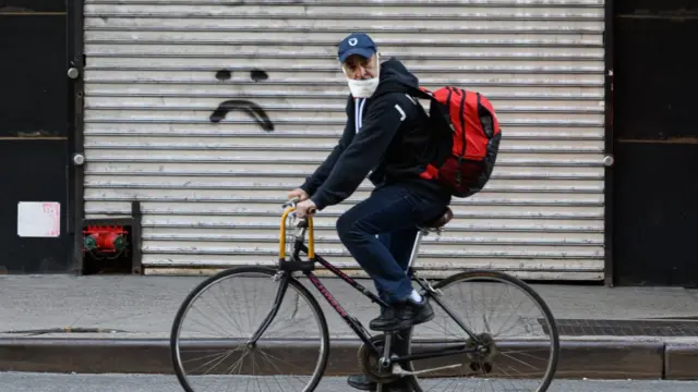 নিউ ইয়র্কের বাসিন্দা মাস্ক পড়ে সাইকেলে চড়ে কাজে যাচ্ছেন, ০৬-০৪-২০২০।