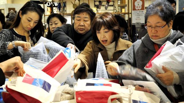 A Mulher Japonesa Está Escolhendo Roupas Para Comprar Imagem de