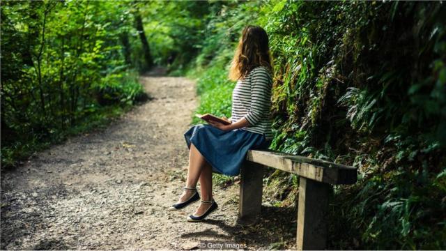 Mulher lê livrojogo do kasinobancojogo do kasinoparque