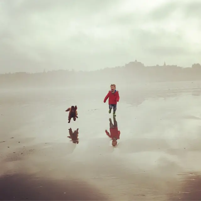 கடற்கரையில் துள்ளிக் குதிக்கும் மகன் லூயிஸ் மற்றும் அவரது செல்ல நண்பன் ஹென்றியை புகைப்படம் எடுத்தவர் கிளாரி ஜேமிசோன்.