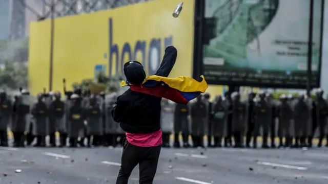 Una manifestante lanza un objeto