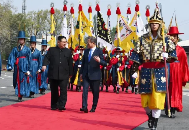 Kim Jong-un y Moon Jae-in caminan y hablan.